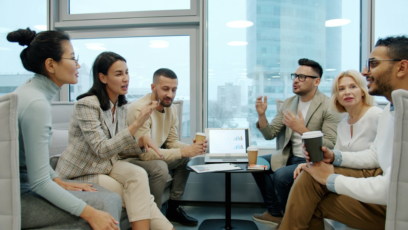 A diverse small business team discussing workplace changes together